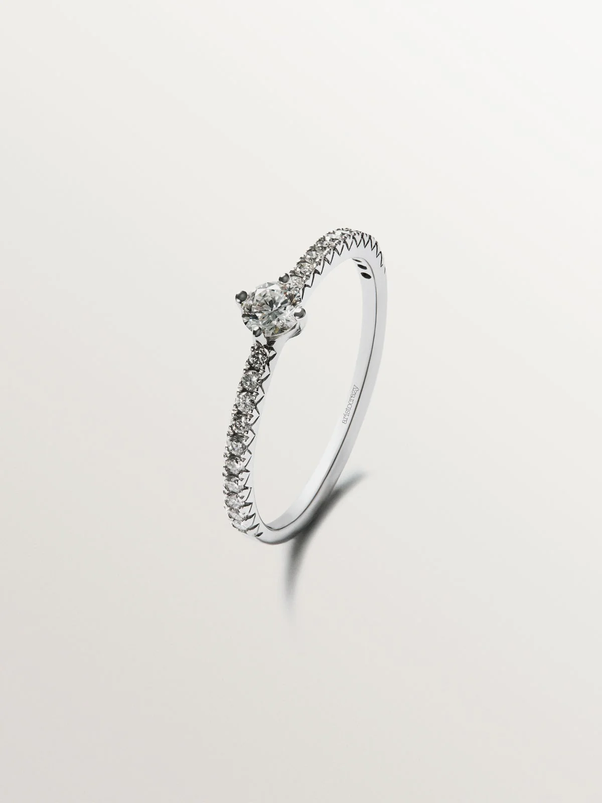 Anillo de oro blanco de 18K con brazo de diamantes y diamante central 0,23 cts