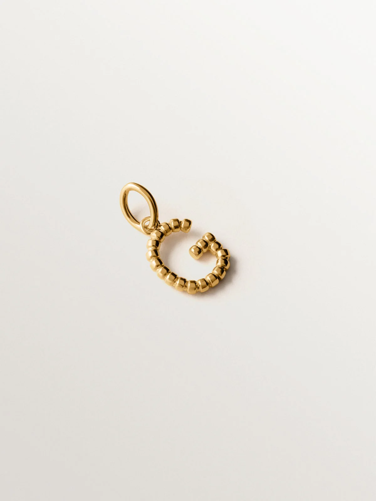 Charm de plata 925 bañada en oro amarillo de 18K con letra G y motivos de esferas