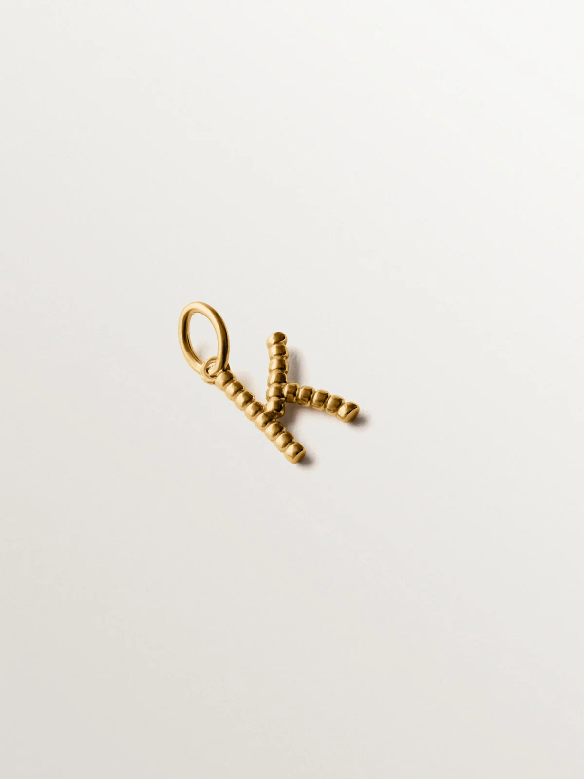 Charm de plata 925 bañada en oro amarillo de 18K con letra K y motivos de esferas