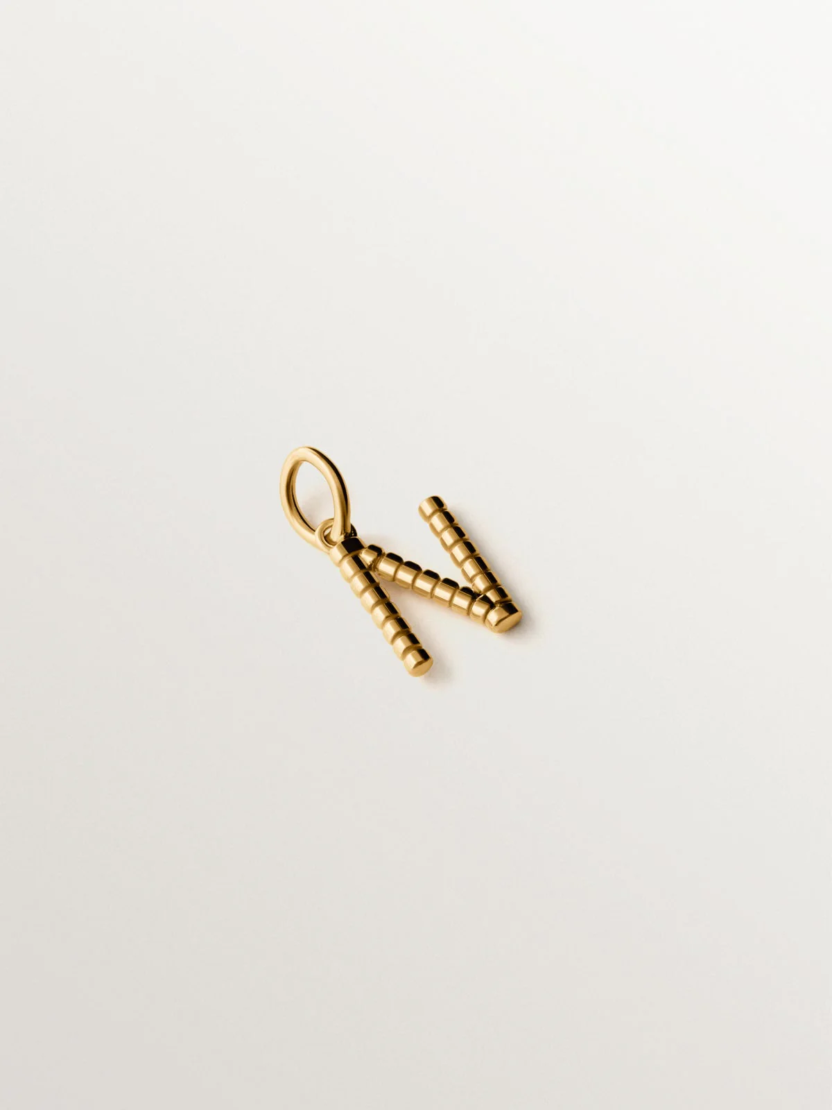 Charm de plata 925 bañada en oro amarillo de 18K con letra N y motivos de esferas