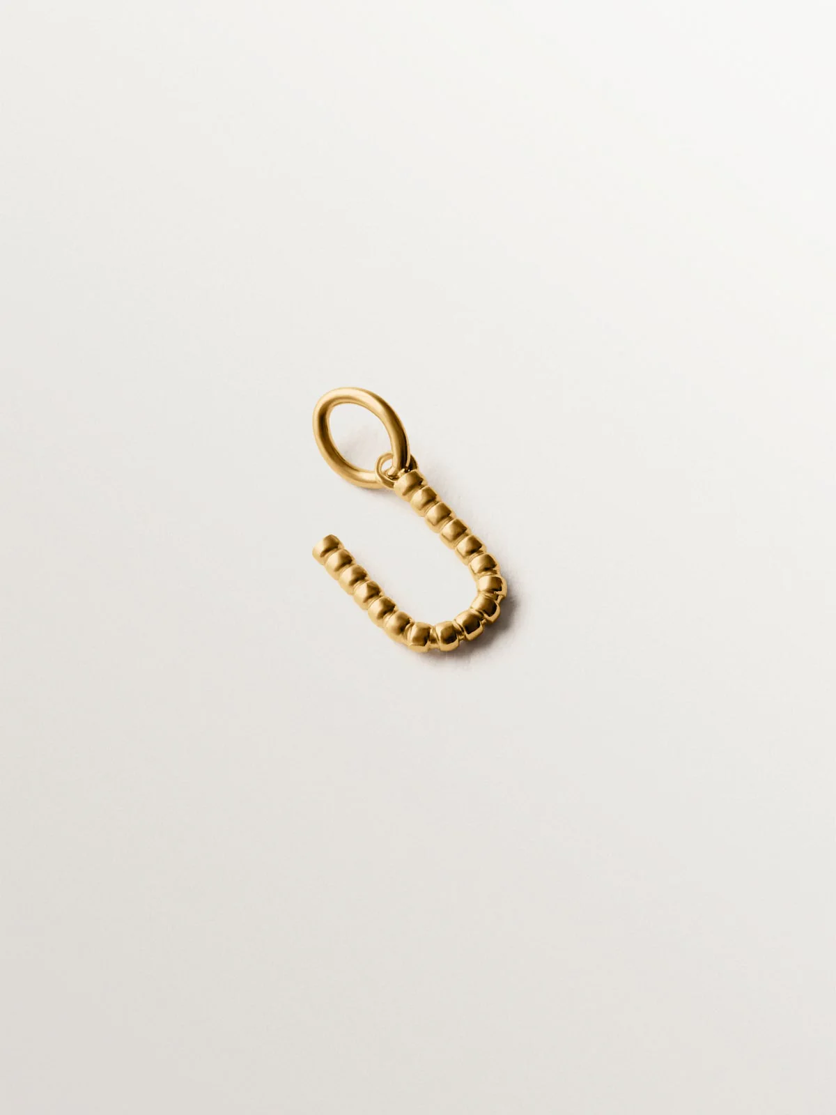 Charm de plata 925 bañada en oro amarillo de 18K con letra U y motivos de esferas