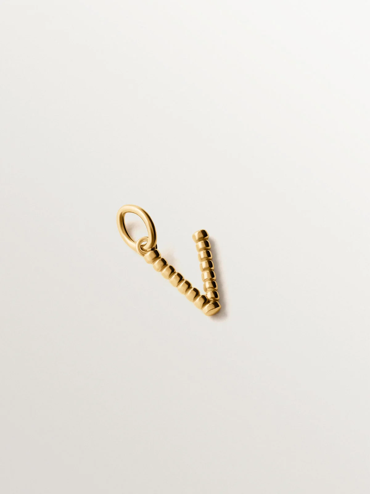 Charm de plata 925 bañada en oro amarillo de 18K con letra V y motivos de esferas