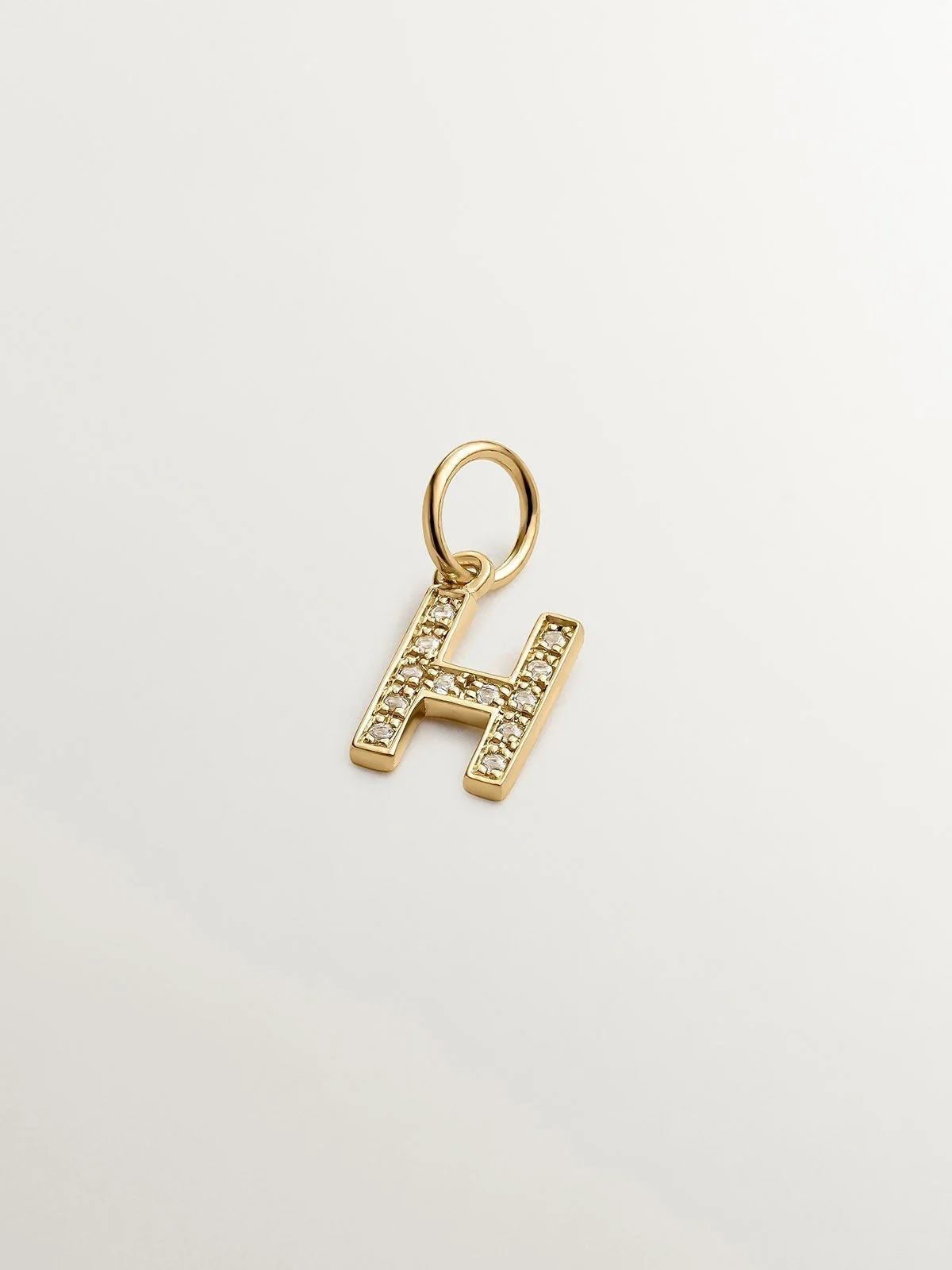 Charm de plata 925 bañada en oro amarillo de 18K y topacios blancos inicial H