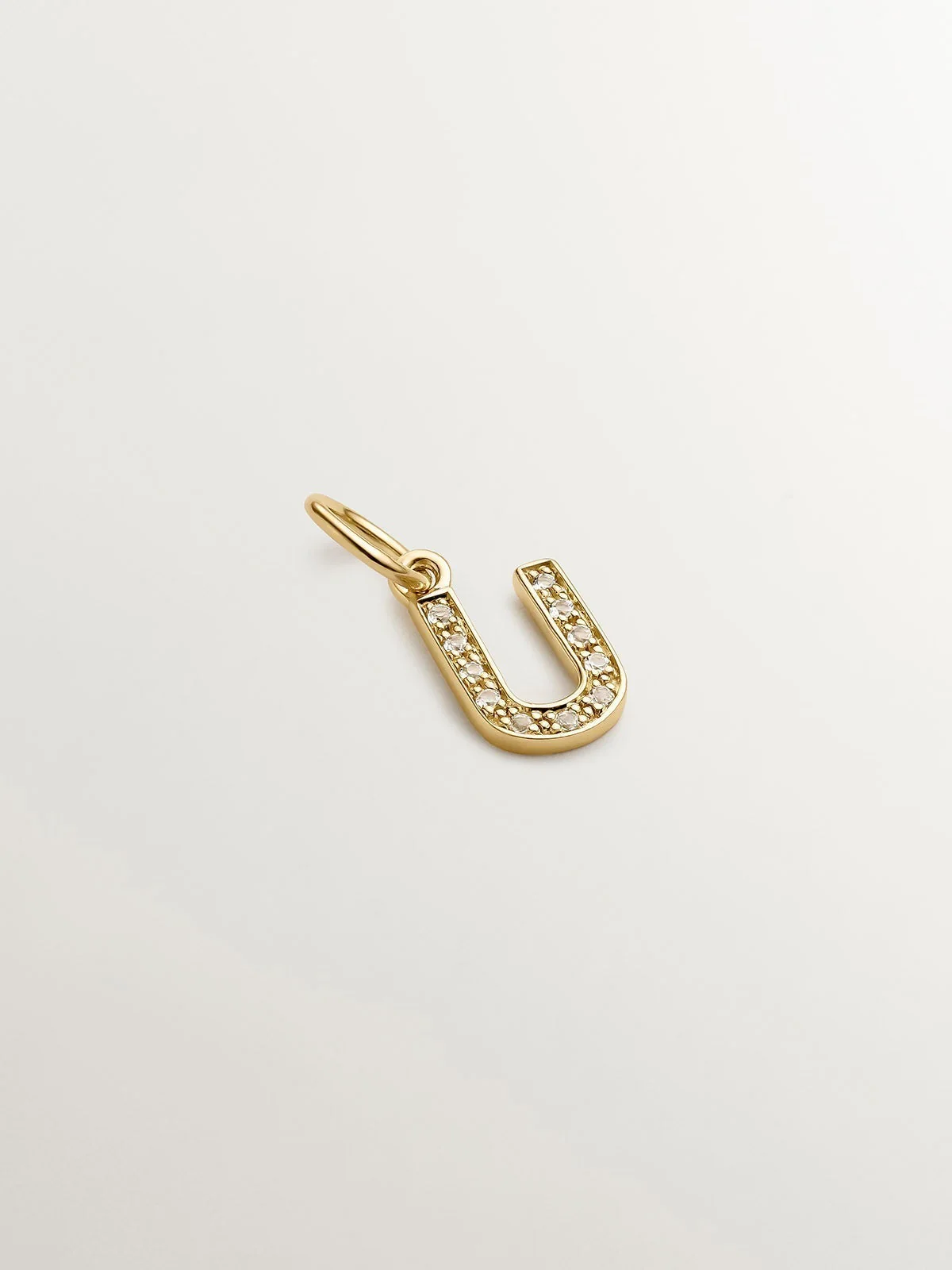 Charm de plata 925 bañada en oro amarillo de 18K y topacios blancos inicial U