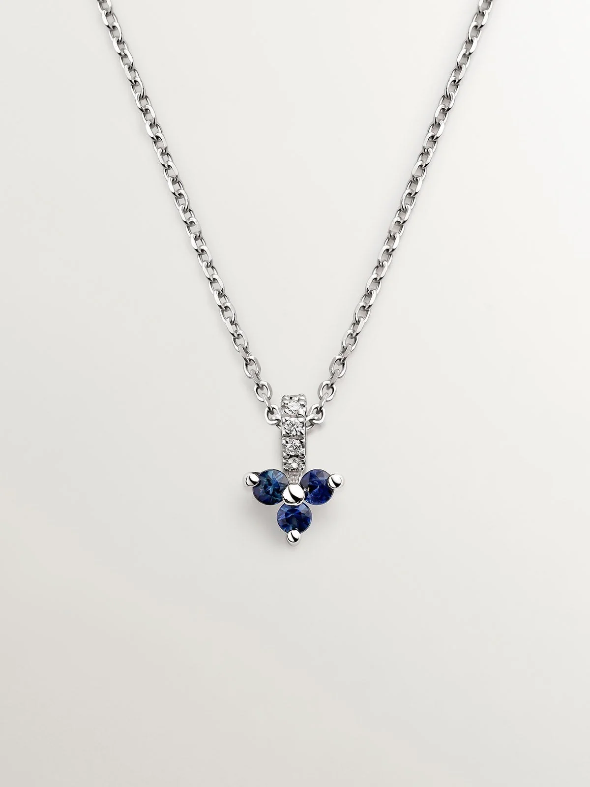 Colgante de oro blanco de 9K con zafiros azules y diamantes