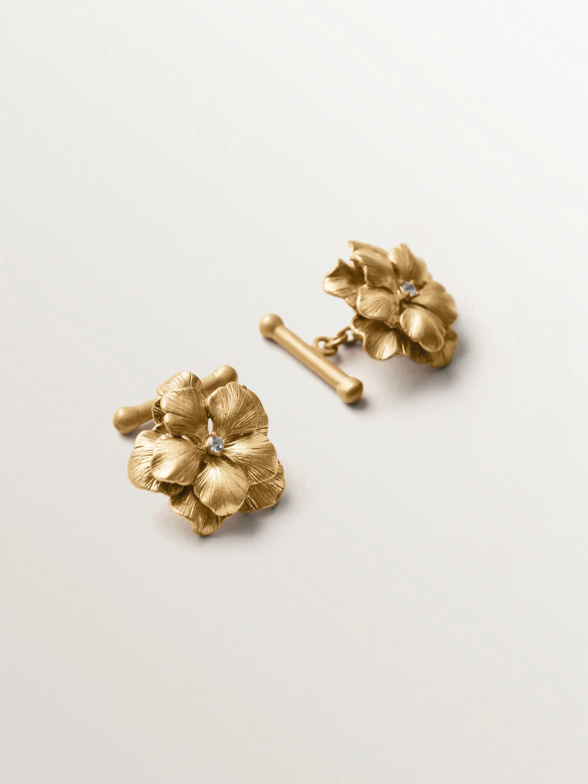 Gemelos bañados en oro amarillo con cristales y forma de flor - Image 5