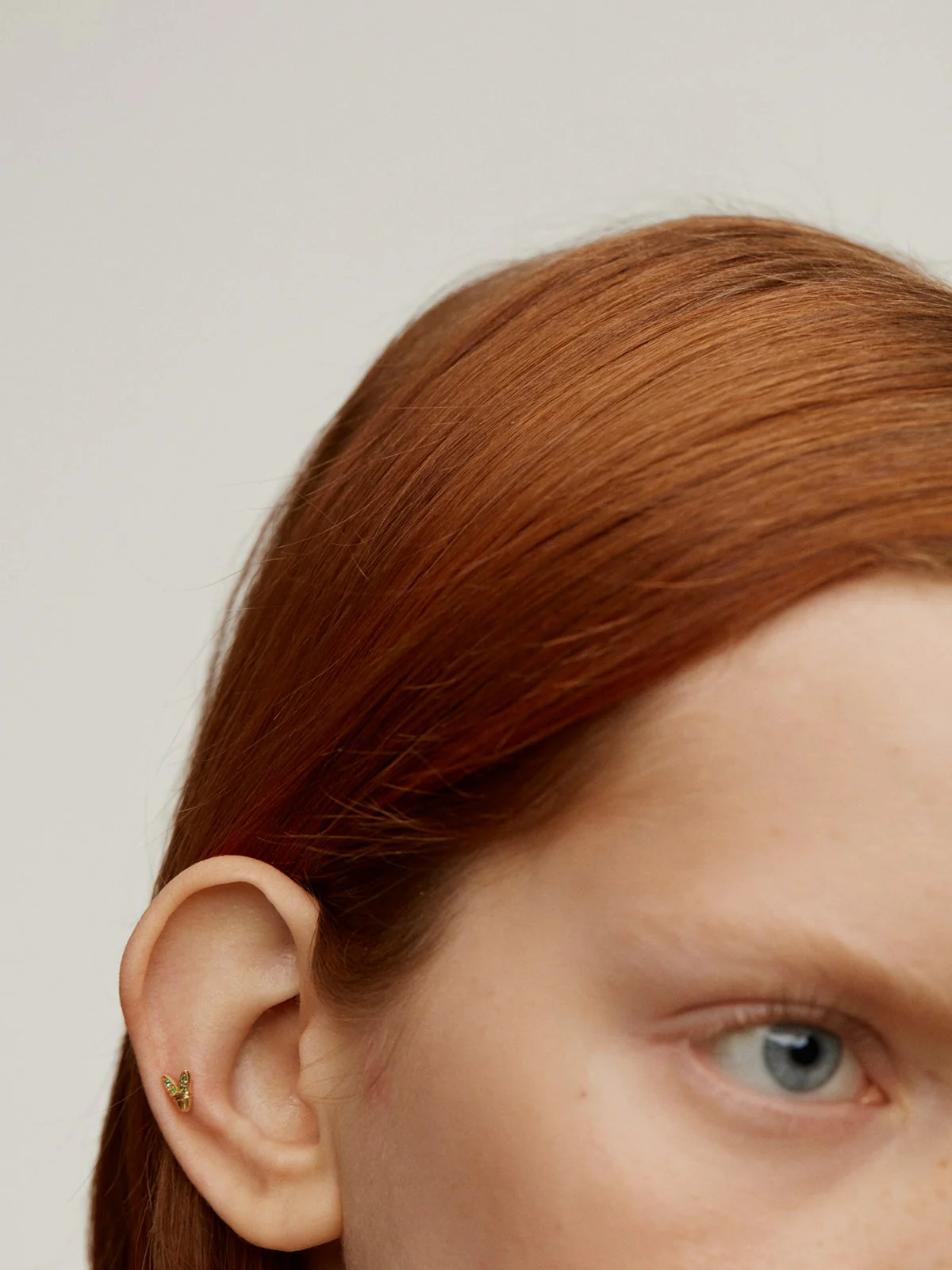 Piercing de oro amarillo de 18K con esmeraldas y forma de alas - Image 2